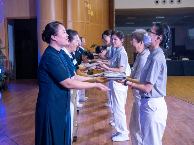 Volunteers in training happily receive their official uniform from Tzu Chi commissioner-mentors. 【Photo by Matt Serrano】