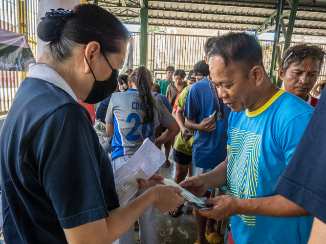 Residents claim their relief goods from Tzu Chi volunteers. 【Photo by Matt Serrano】