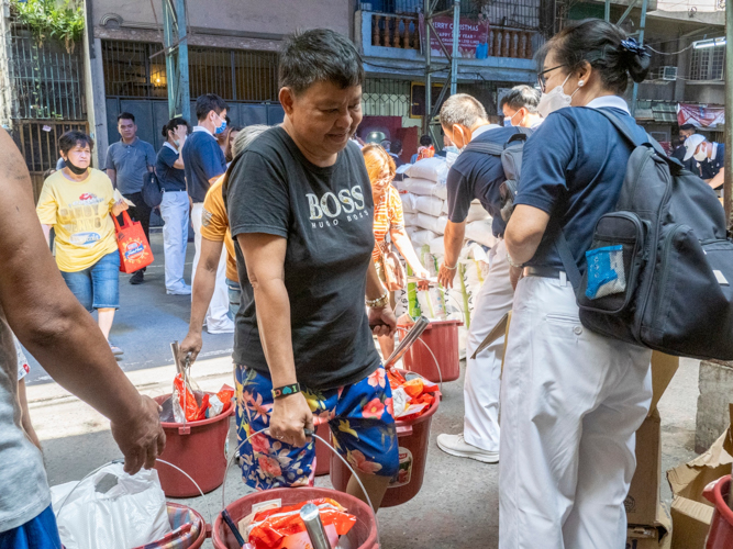 Tzu Chi volunteers help beneficiaries collect their relief goods for their families. 【Photo by Matt Serrano】