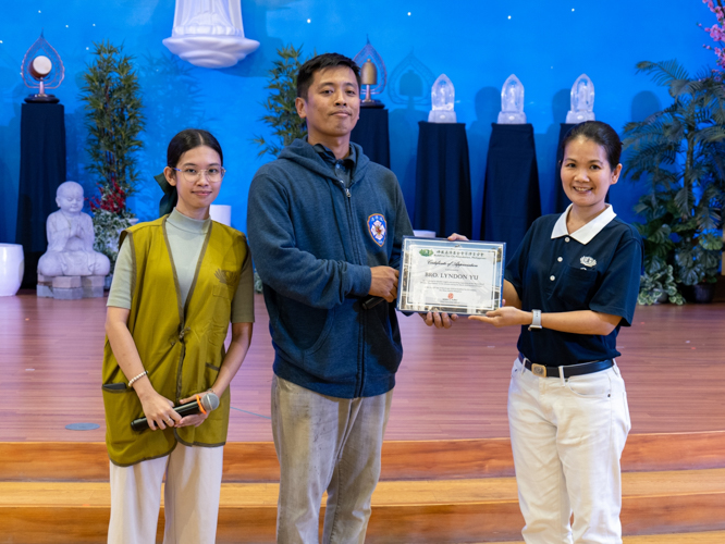 Tzu Chi volunteer and longtime firefighter Lyndon Yu accepts a certificate of appreciation for leading a lecture and simulated fire training exercise during the March 10 Humanity class for Tzu Chi scholars. 【Photo by Marella Saldonido】