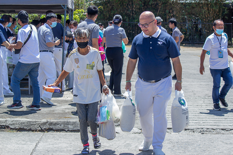 Tzu Chi volunteers prepare vegetarian lunch packs for beneficiaries to receive after claiming their 20kg rice, bag of groceries, and personal hygiene kit. 【Photo by Marella Saldonido】