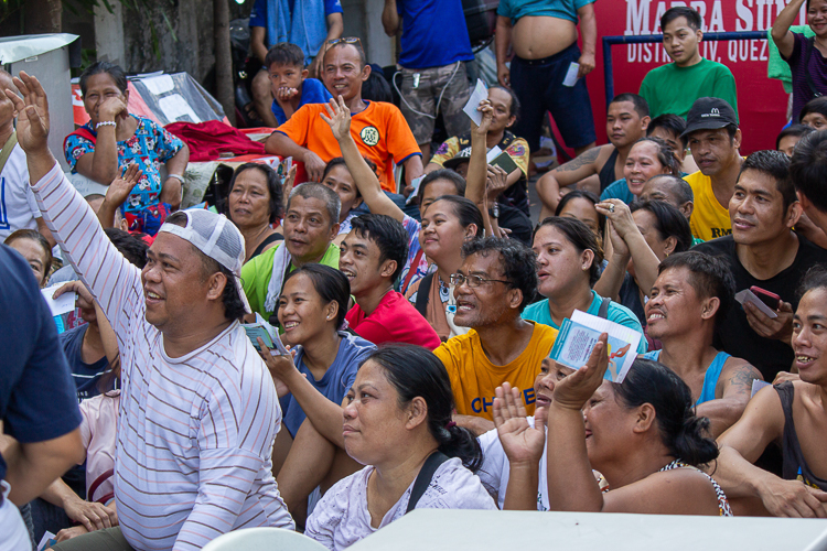 Residents of Barangay Damayang Lagi, Quezon City, cheer as they discuss the distribution of relief goods. 【Photo by Marella Saldonido】