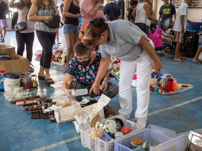 A customer surveys bazaar items with the help of a Tzu Chi volunteer. 【Photo by Matt Serrano】
