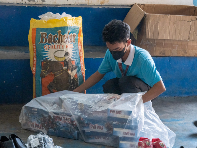 A Tzu Chi scholar unpacks boxes of toys for the bazaar. 【Photo by Matt Serrano】