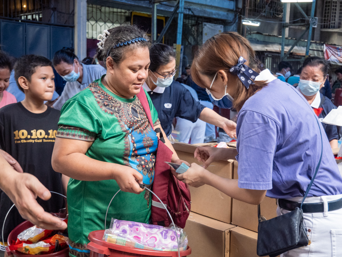 Renira Alvar receives the essential goods and gift certificate during the fire relief. 【Photo by Matt Serrano】