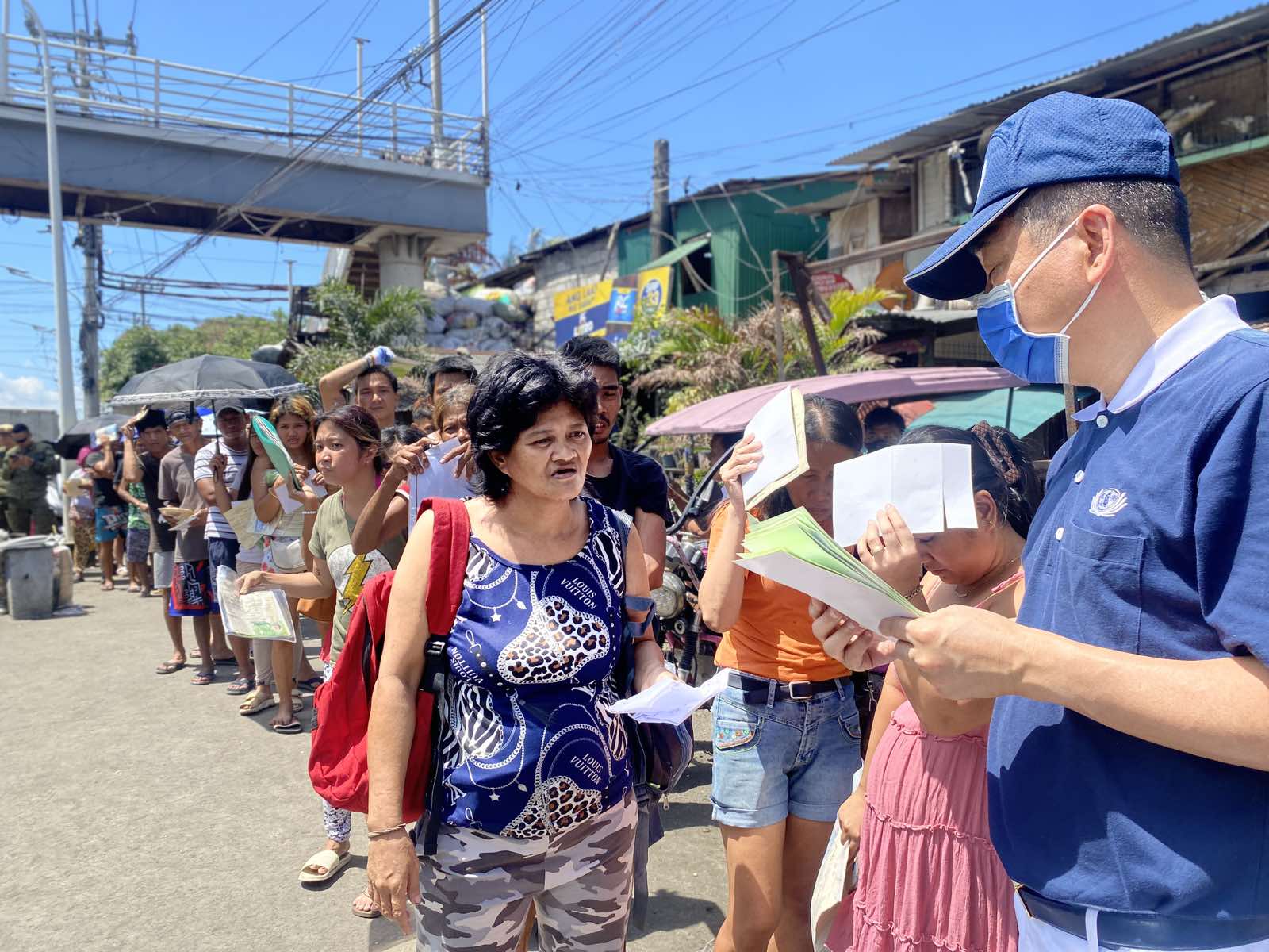 Beneficiaries line up to claim their GI sheets from Tzu Chi volunteers. 