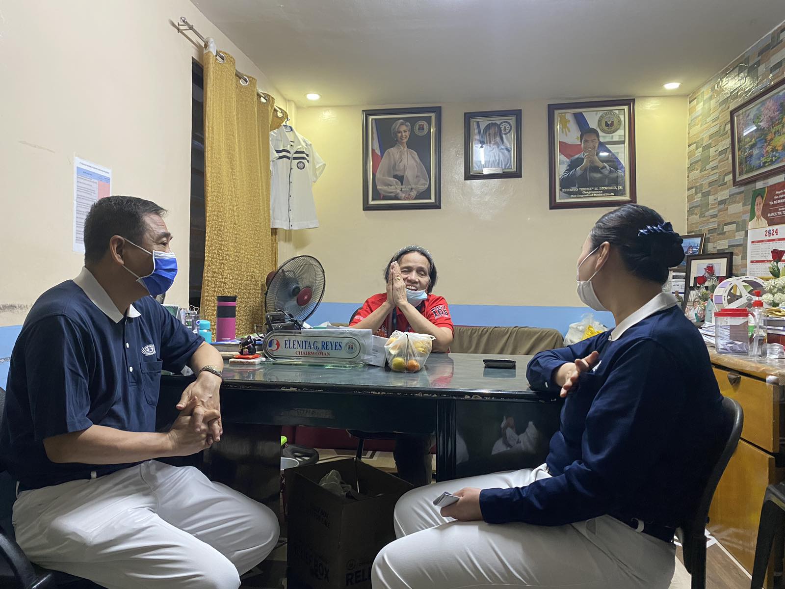 Tzu Chi volunteers Kevin King (left) and Sharon Sy (right) pay a courtesy call to Barangay 105 Chairwoman Elenita “Leny” Reyes during the distribution of GI sheets to the community’s fire victims.