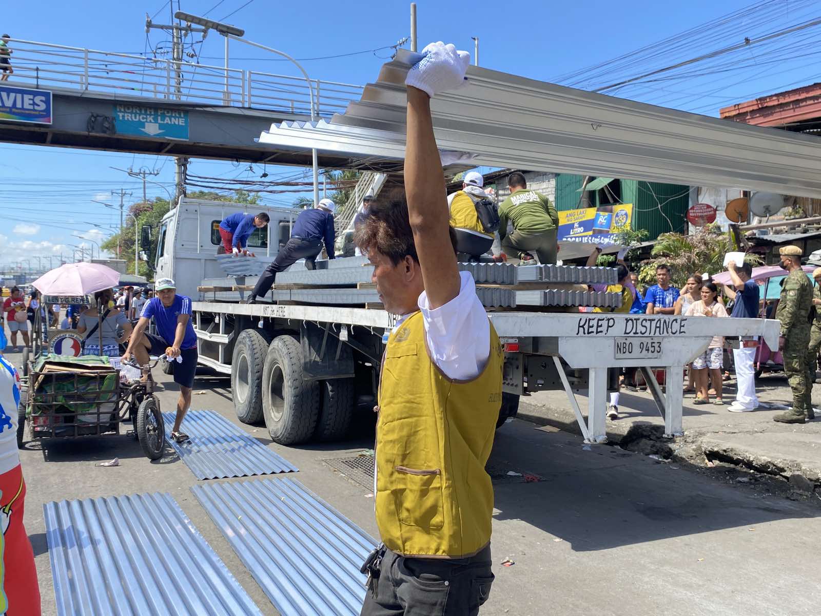 Volunteers tolerate the sweltering heat on April 2 as they unload galvanized iron (GI) sheets for distribution. Four sheets were given to each of the 625 families that lost their home to a fire in Barangay 105, Tondo, Manila, last March 21. 