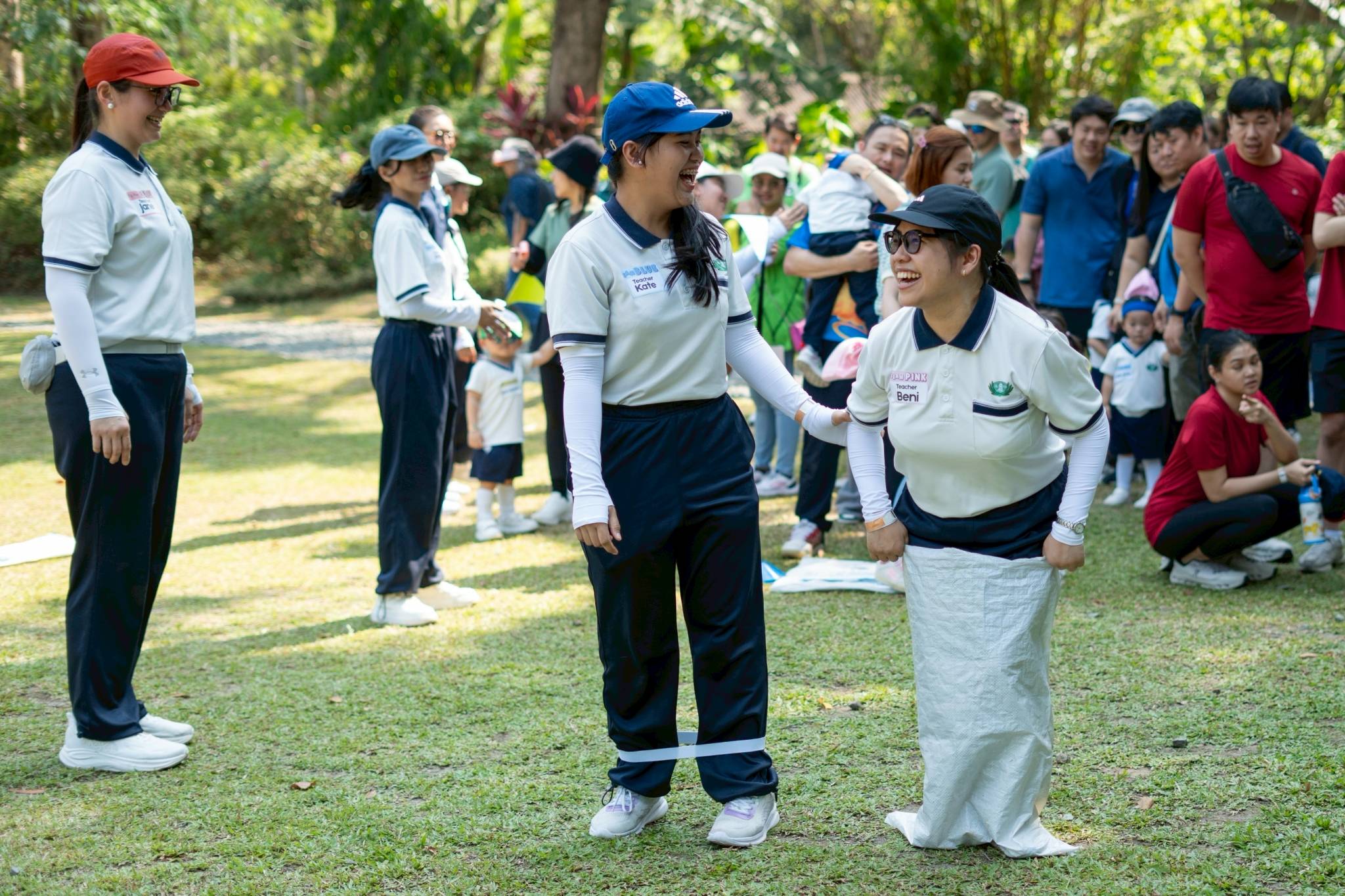 Faculty staff demonstrate the game mechanics of the sack race to the participants.