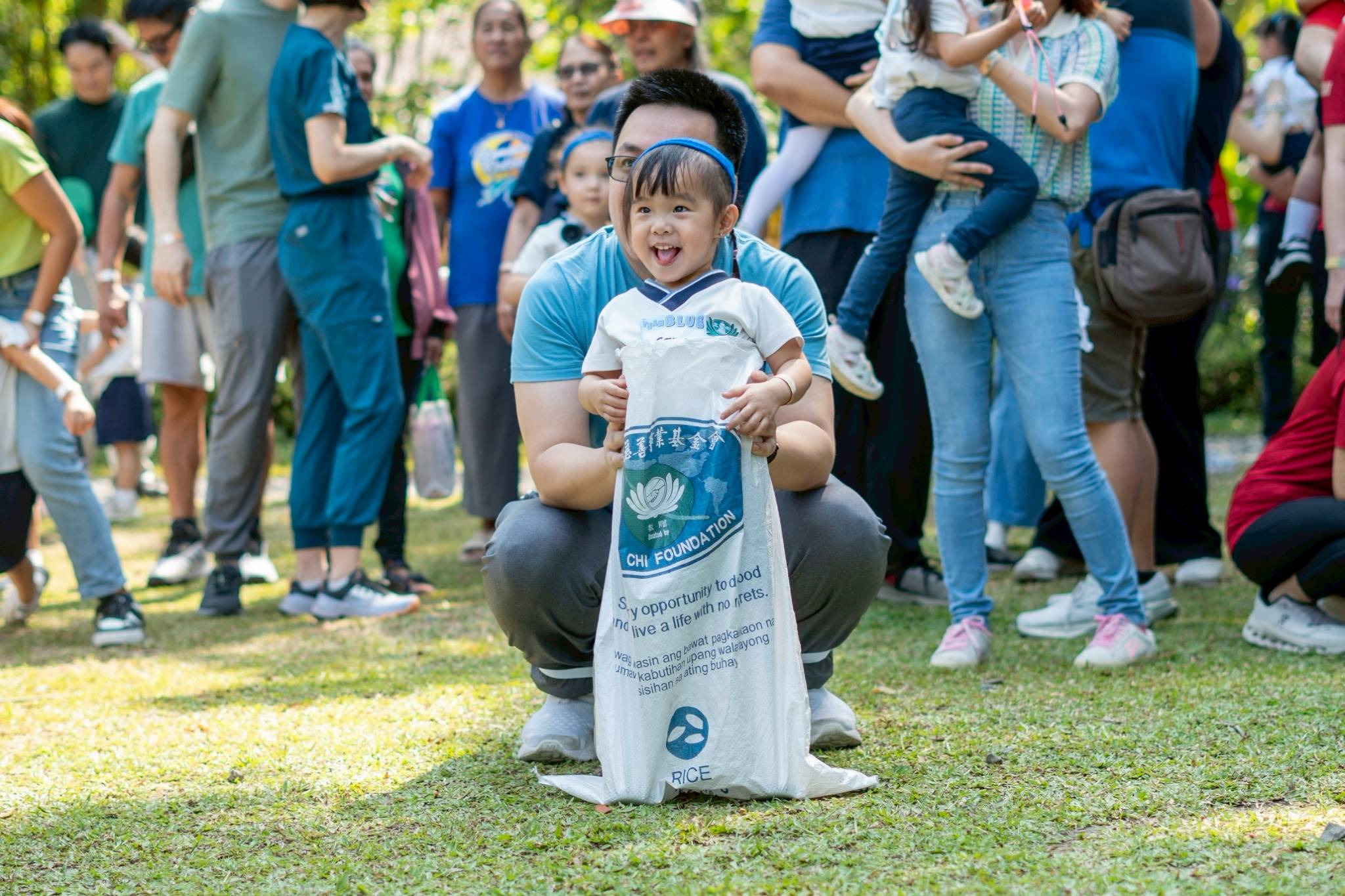 A preschooler cannot hide her enthusiasm at the sack race. 