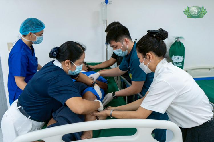 Tzu Chi volunteers help in caring for a patient after a successful surgery.