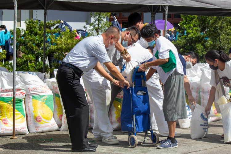 Scholars and medical assistance beneficiaries claim their 10kg sack of rice and grocery items. 【Photo by Marella Saldonido】