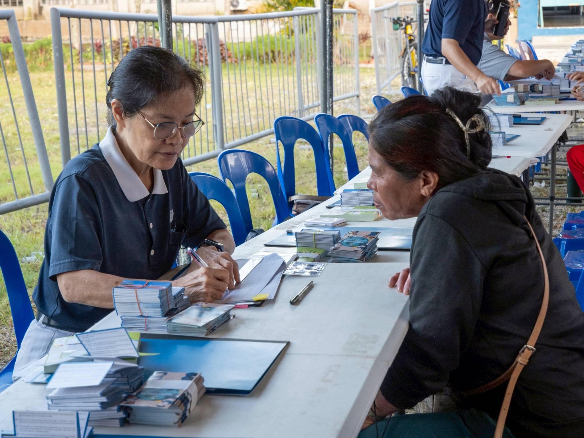Tzu Chi Foundation volunteer Elvira Chua assists in the registration process.