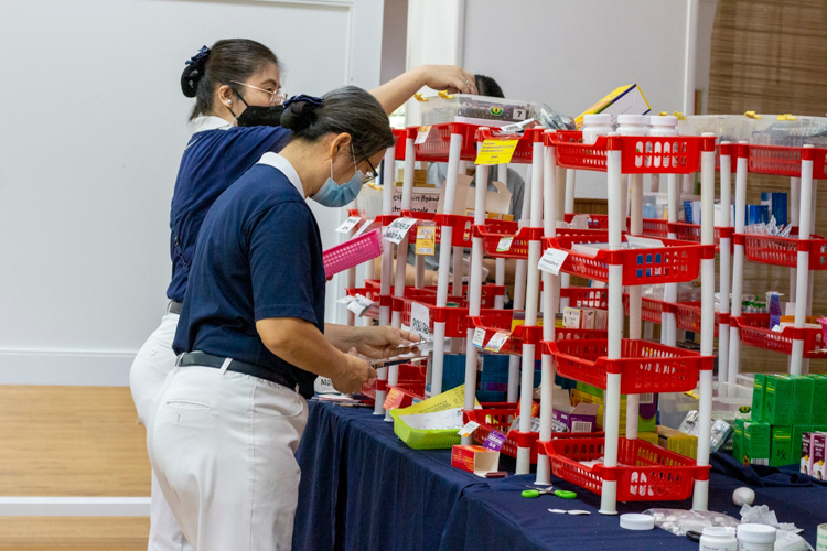 Volunteers man the pharmacy where patients claim their prescribed medicines. 【Photo by Matt Serrano】