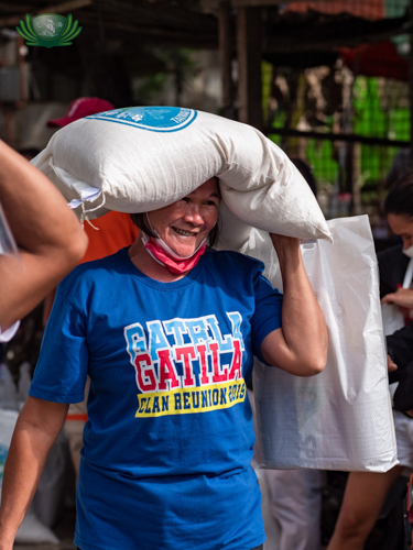 A scavenger beneficiary is all smiles as she leaves Pantay Elementary School with her rice and grocery relief goods. 【Photo by Daniel Lazar】