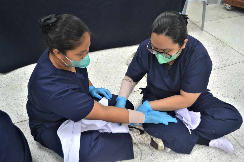 Marielle Hernandez (right) practices first aid techniques as part of the caregivers’ training curriculum.