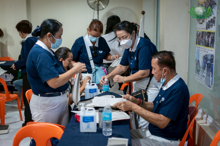 Tzu Chi volunteers help arrange patient charts and information.
