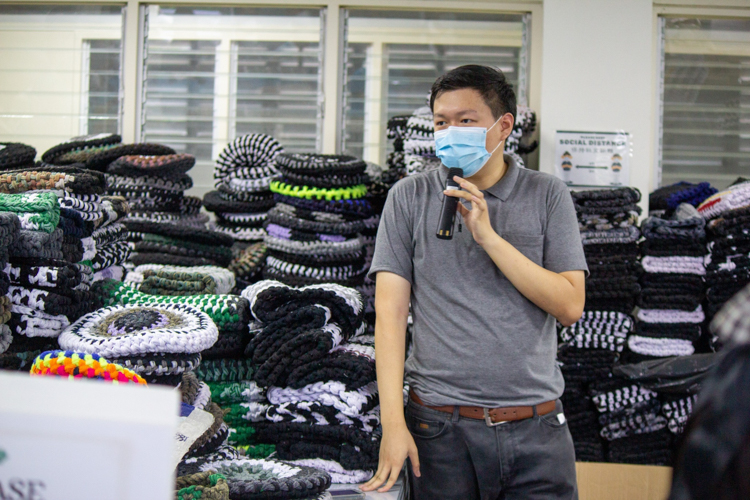 Tzu Chi Partnerships Assistant Clifford Co shows scholars seat covers made of excess sports sock materials—one of the products created by volunteers of Tzu Chi’s recycling program. 【Photo by Marella Saldonido】