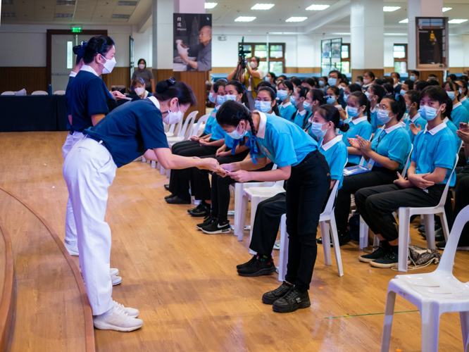 Tzu Chi Philippines Deputy CEO and OIC Woon Ng (left) presents a scholar from Pampanga with a scholarship certificate. 【Photo by Daniel Lazar】