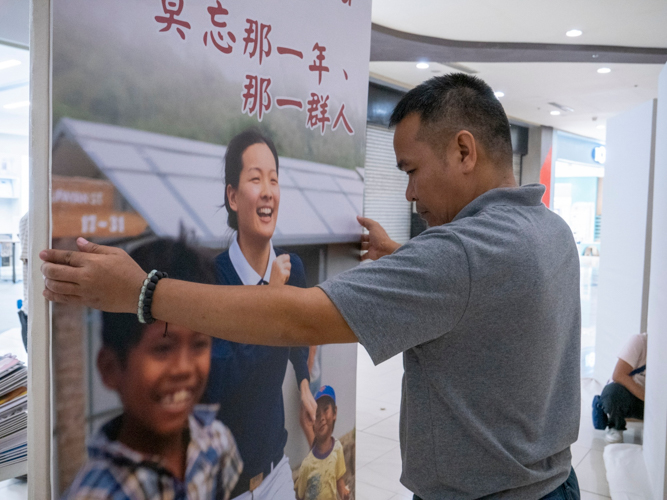 Tzu Chi volunteers set up the photo and video exhibit at Robinsons North Tacloban. 【Photo by Matt Serrano】