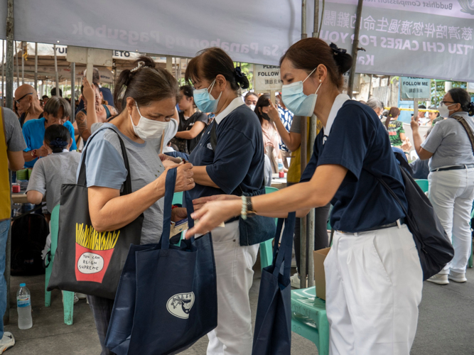 Oroquieta resident Lulu Osit (in gray) receives aid from a volunteer. 【Photo by Matt Serrano】