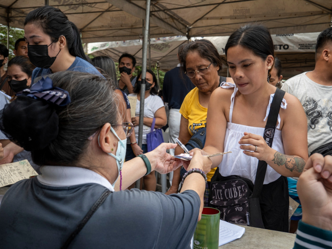 A fire beneficiary hands over requirements to a volunteer. 【Photo by Matt Serrano】