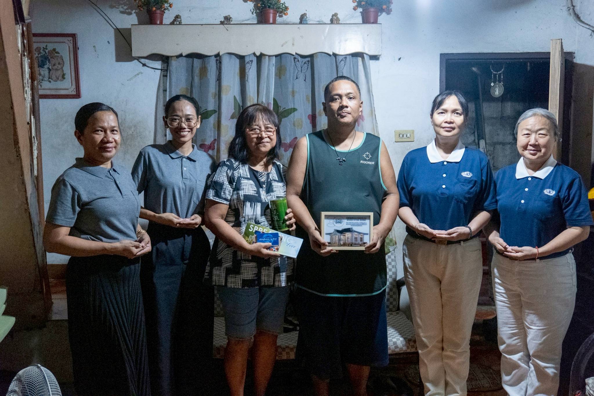 Angelina and Ansel Belino (third and fourth from left) join Tzu Chi volunteers and staff for a photo during their care visit on June 6.