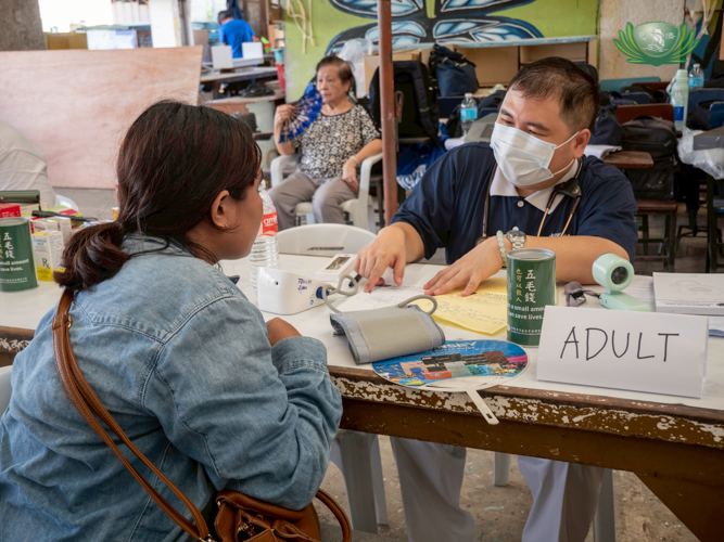 Tzu Chi International Medical Association member and volunteer Dr. Benito Lim Hong III helps assess patients.