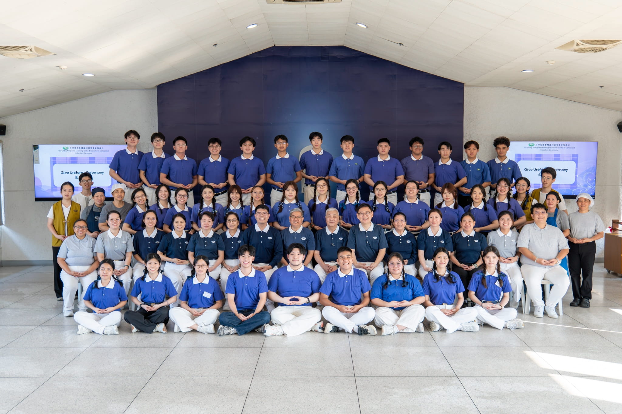 Wearing their Tzu Chi Youth (TYCY) uniforms, nine newly inducted members (front row, seated) gather for an official group photo with TCY members and Tzu Chi volunteers and staff.