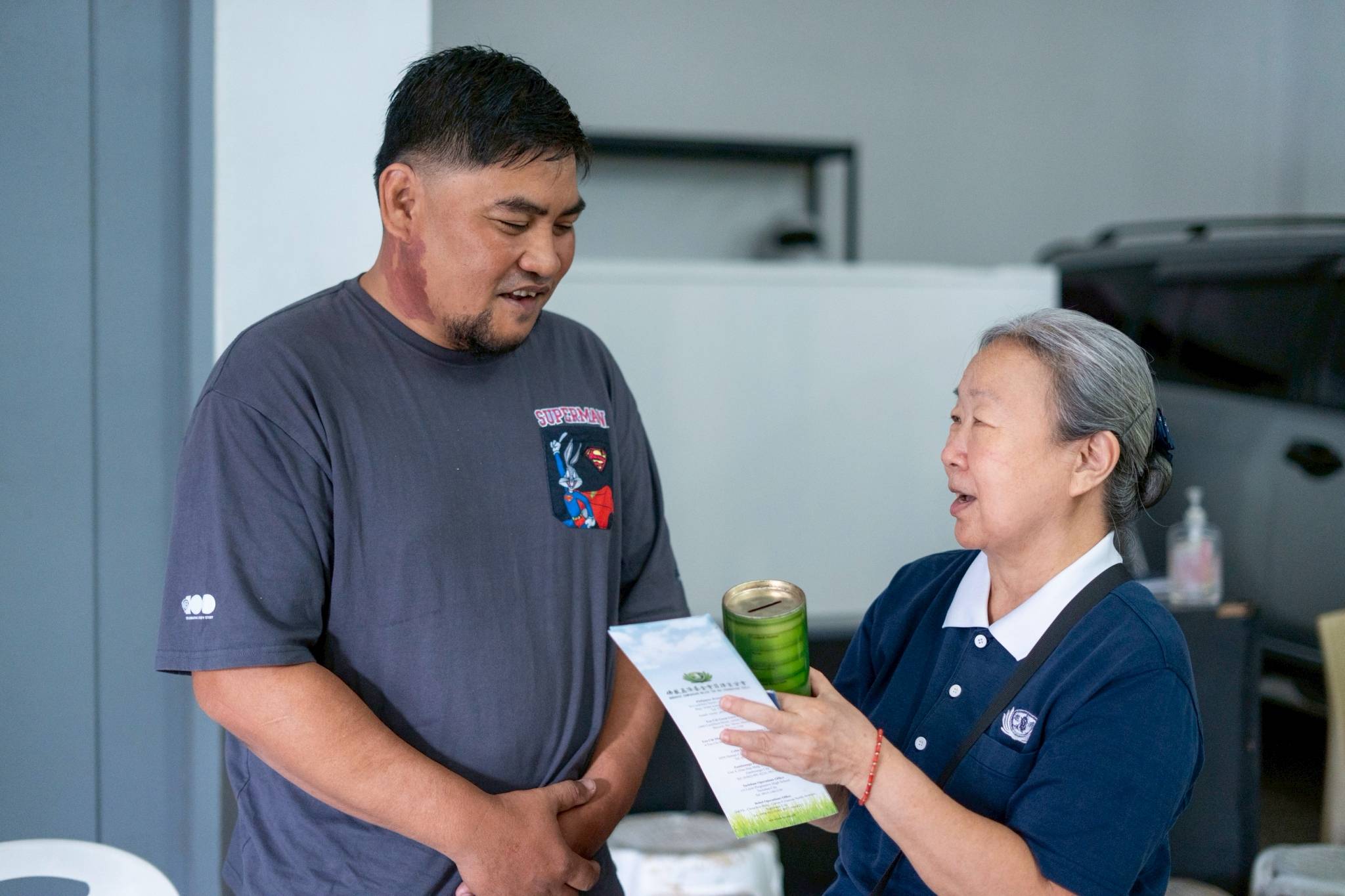 Tzu Chi volunteer Violeta Chua presented Mechel Banga with a coin can and a lamp commemorating Tzu Chi's years of compassion. Mechel said he follows the organization on social media, is deeply inspired by its missions, and shares its good deeds with his workmates.