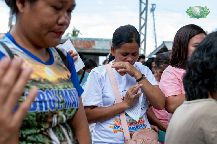 Residents bow in silent reflection and prayer during a relief distribution in Bago City. Their hearts are heavy with sorrow yet lifted by hope.