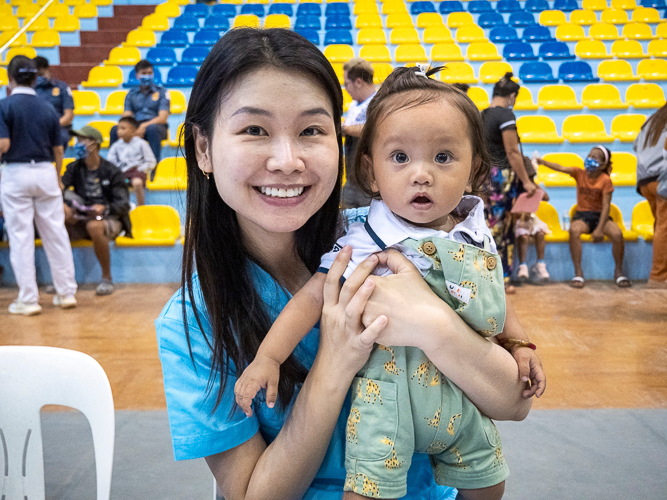 Dr. Catherine Uy Cano joyfully takes a photo with one of the patients. 【Photo by Matt Serrano】