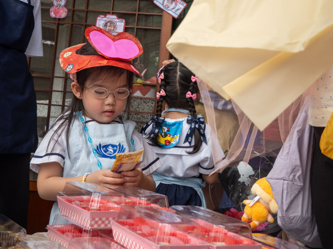 This young one practices her entrepreneurship skills while handling her customers’ payments.