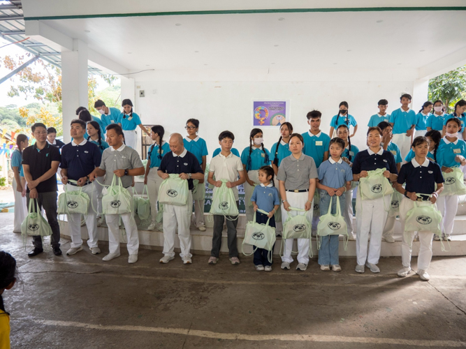 Tzu Chi volunteers and scholars help in distributing the school supplies to the students.