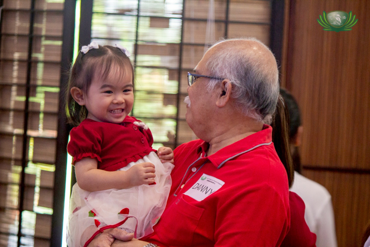 Amidst the fun games, a grandfather shares a smile with his granddaughter.