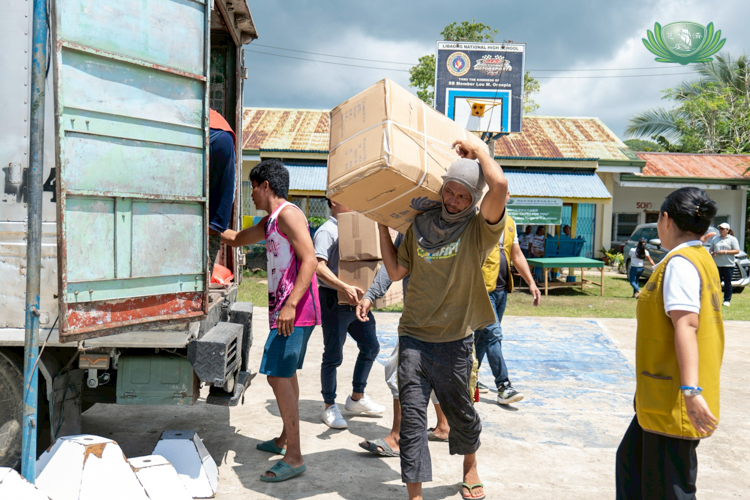 Despite being a beneficiary himself, James Bulhot (with box) was more than happy to help beneficiaries in carrying the relief goods. 