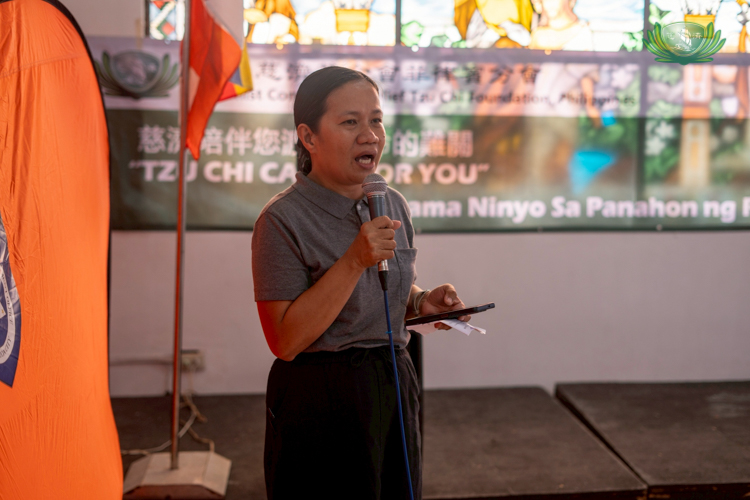 Tzu Chi staff member Julie Collado comforts affected families during a sharing session before the distribution of relief.