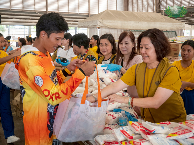 Jacinto Abata smiles while collecting grocery items such as milk, oil, soy, salt, coffee, sugar, and other necessities.