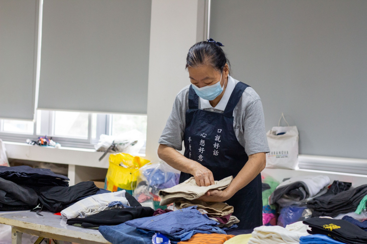A Tzu Chi volunteer works hard as she sorts and folds clothing for the relief operations.