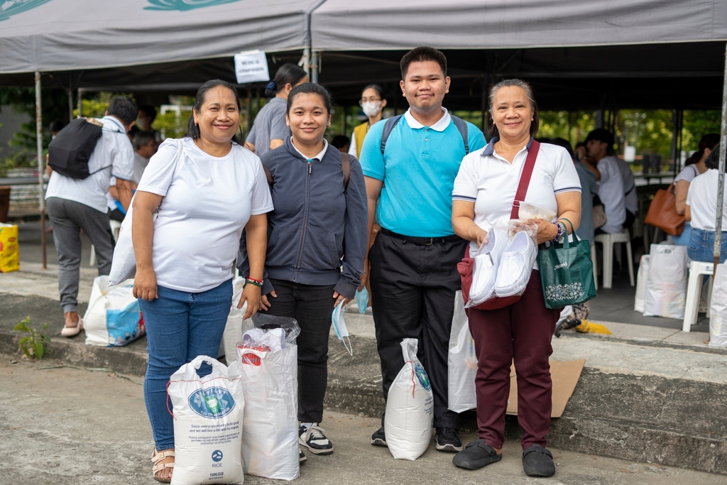 Tzu Chi scholars and their parents are all smiles after claiming their rice and grocery allowance.