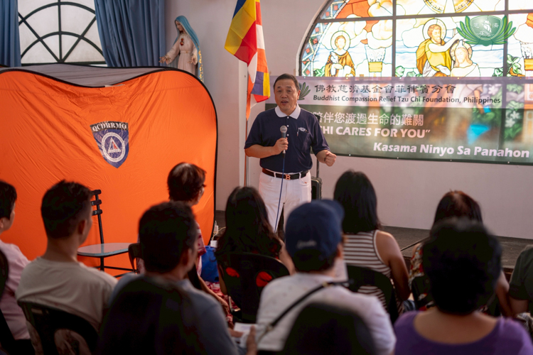 Tzu Chi volunteer Benson Lao gives families a brief history of the Tzu Chi Foundation.