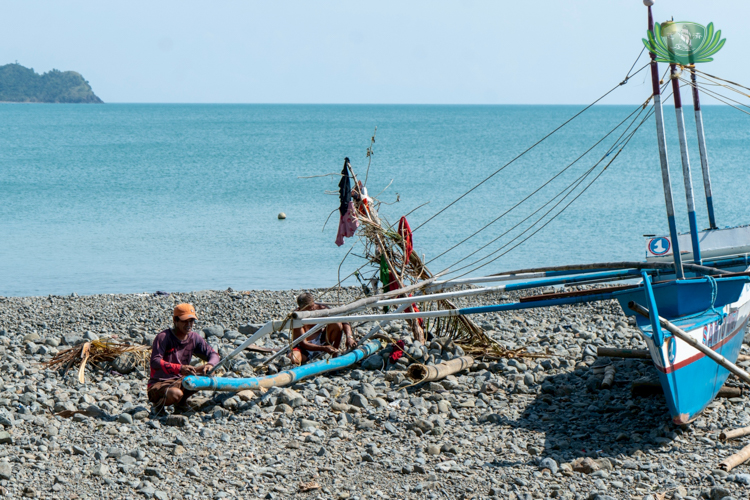 A fisherman from Paltic, Dingalan, works to repair his boat, determined to restore his means of livelihood despite the devastation along the coast.