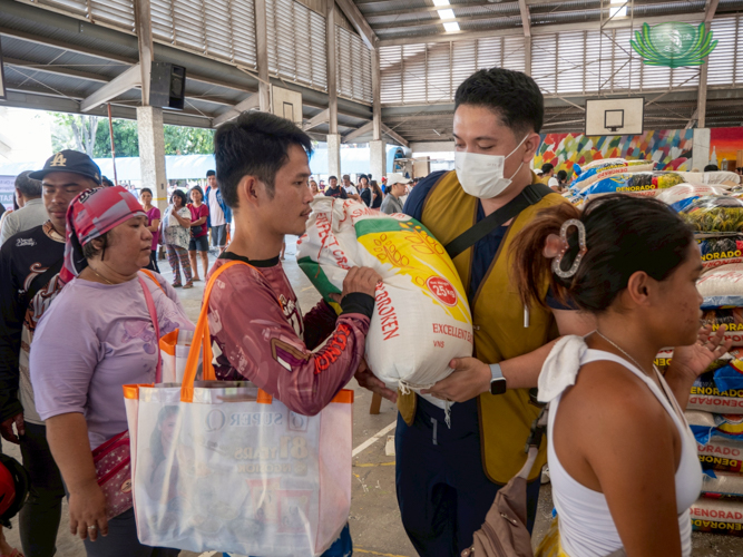 Their volunteer efforts go beyond medical consultations; Edil-Joshua Ganas (in Tzu Chi vest) helps carry sacks of rice to distribute to beneficiaries.