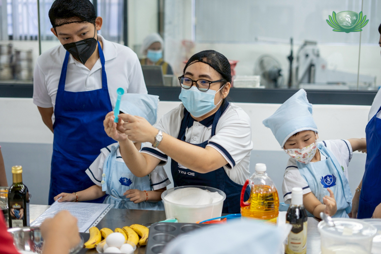 A preschool teacher shows students which measuring tools to use for baking.