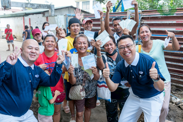 Residents of La Carlota pose with Tzu Chi volunteers as they receive grocery vouchers, grateful for the support that will help fill their tables this Christmas.