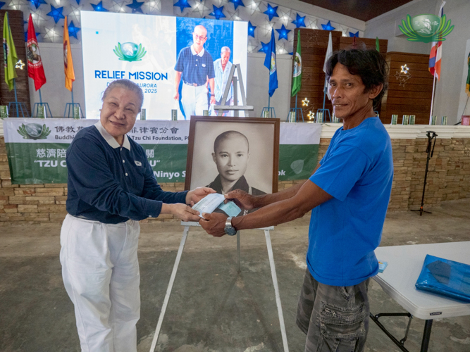 A beneficiary receives cash assistance to help him rebuild his home.