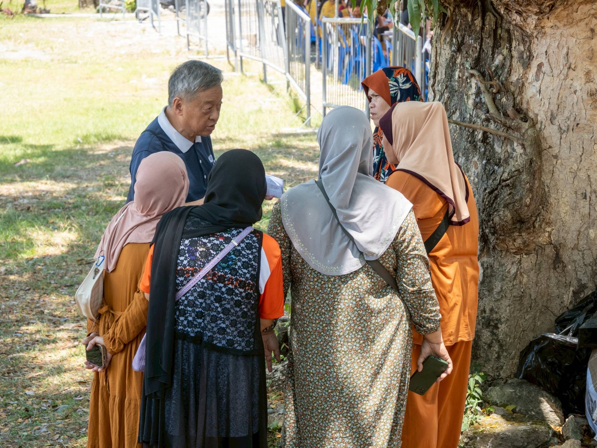 Tzu Chi volunteer Johnny Kwok engages with Muslim beneficiaries, responding to their inquiries regarding the relief assistance.