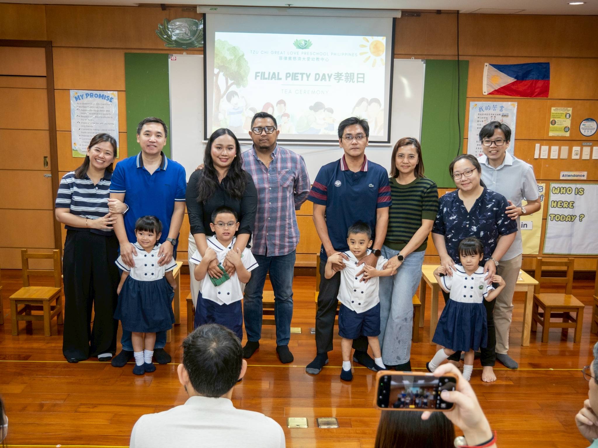 Beaming with pride over their children’s growth, parents posed together in a heartfelt moment.
