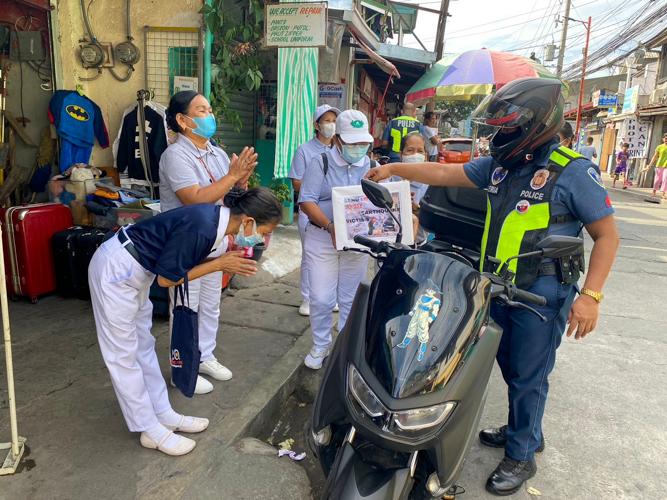 Tzu Chi volunteers bow in gratitude to a policeman for his donation. 【Photo by Matt Serrano】