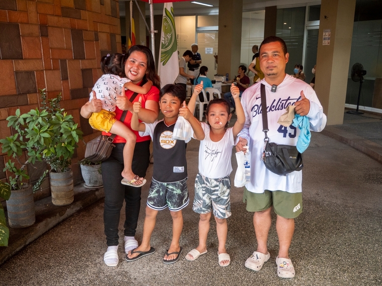 Zernilyn Mangalo (left, in red) and James Posadas (first from right) happily pose for a photo with their children after their dental procedures.